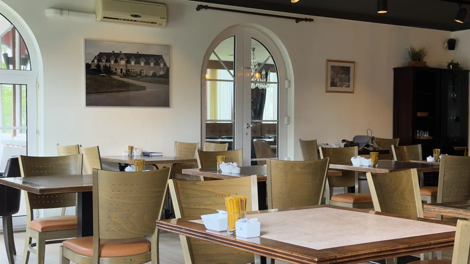 De lichte ontbijtzaal met gedekte tafels