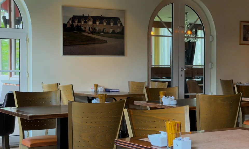 Zaal met gedekte tafels, klaar voor een gezelschap