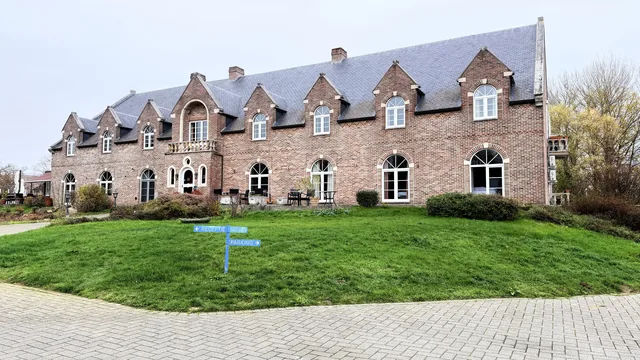 De oprit met de wegwijzers naar receptie en parking
