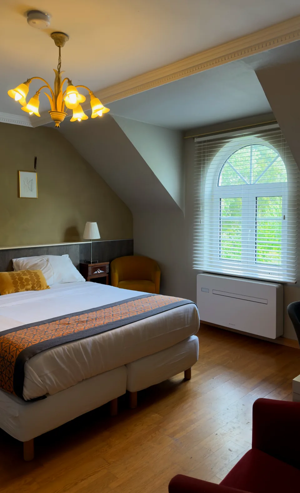 Hotelkamer met boogvenster en uitzicht op het groen
