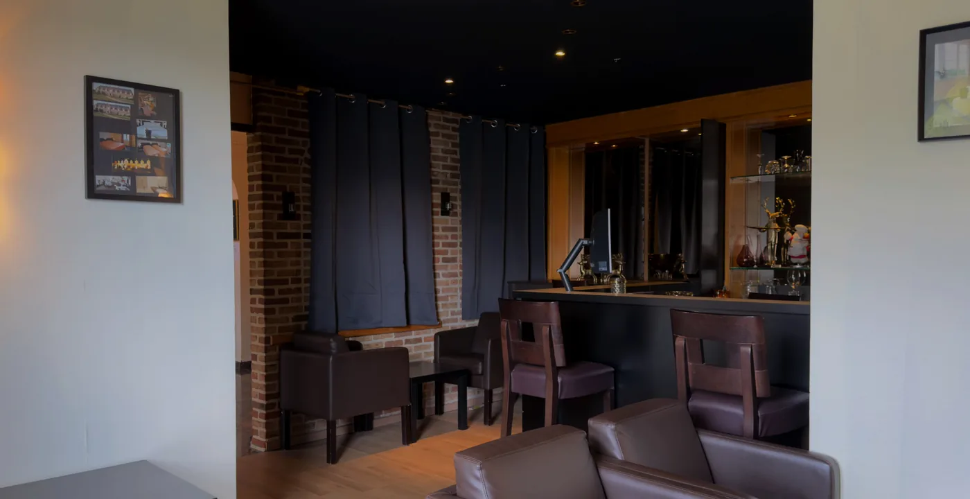 De lounge met leren zetels en de bar