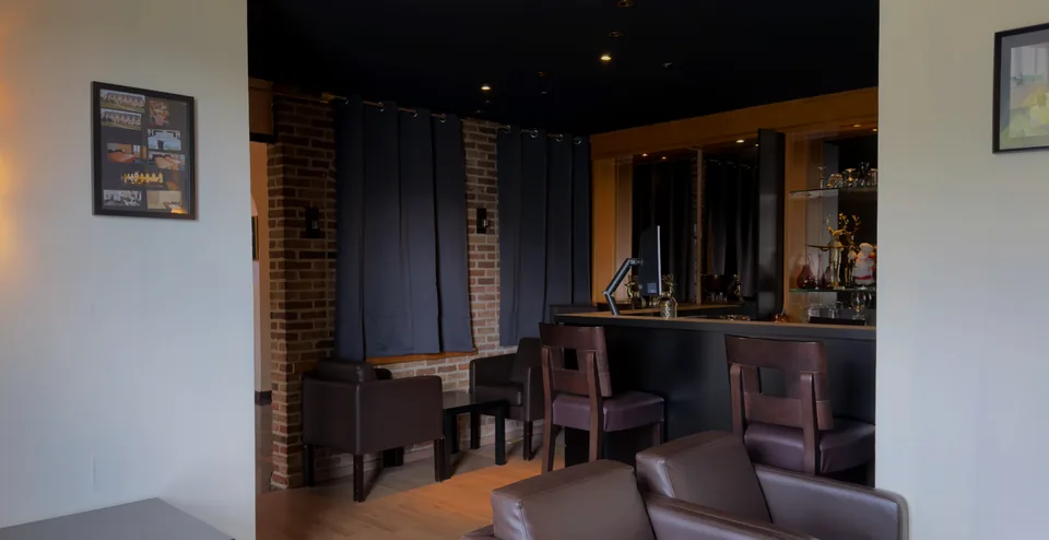 De lounge met leren zetels en de bar