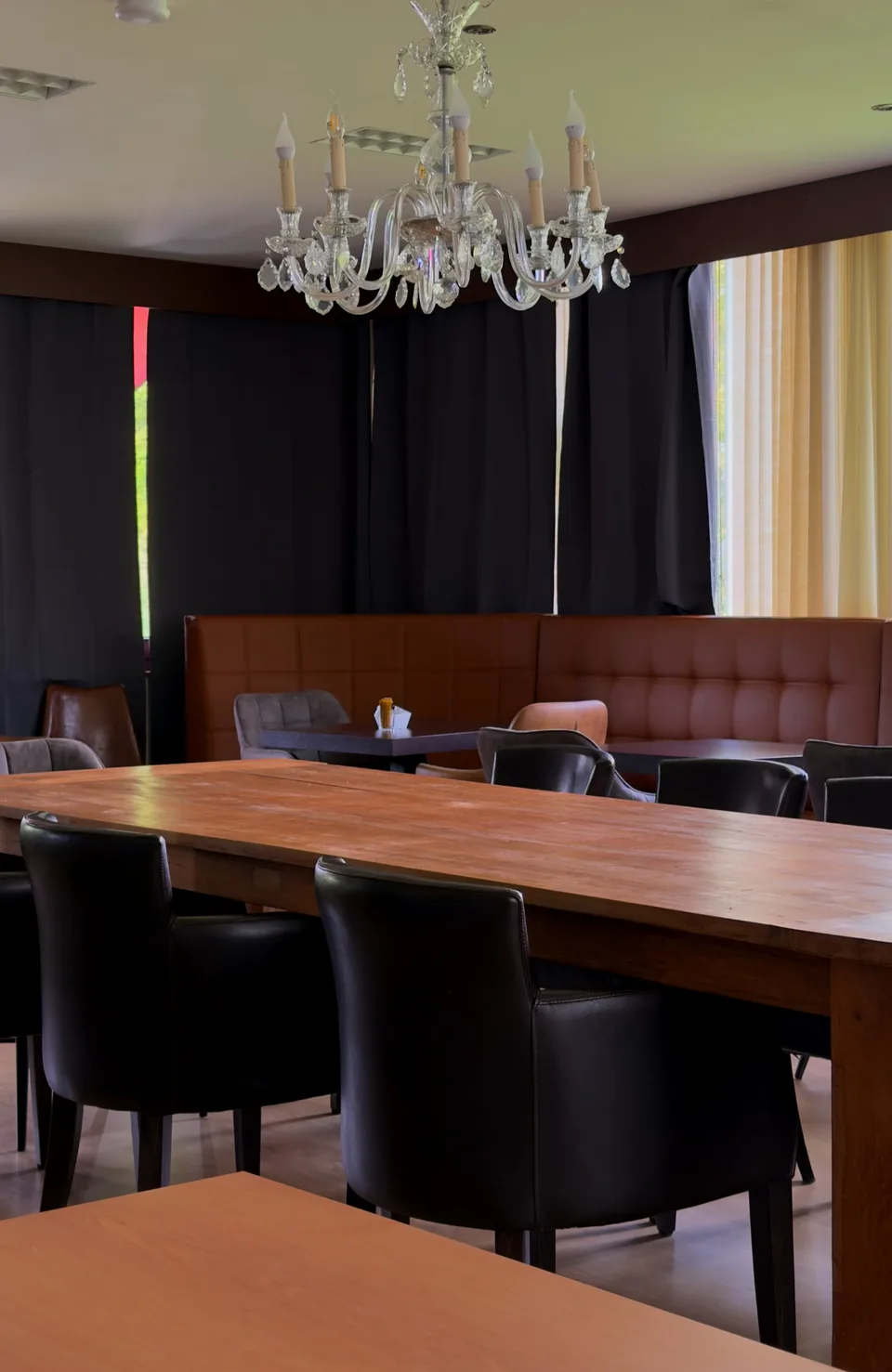 De zaal met kristallen luster en de lange houten tafel
